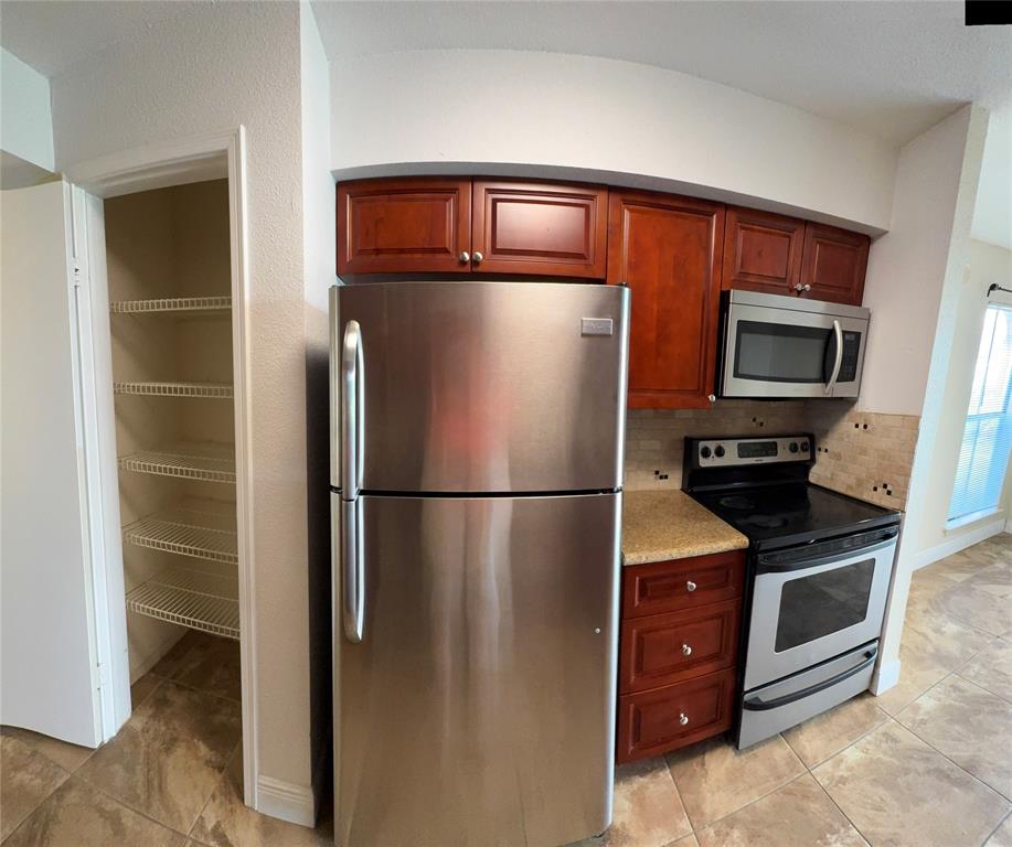 805 Riverside Drive, Unit 1112 Coral Springs, FL 33071 - Photo 4 of 26 a metallic refrigerator freezer sitting in a kitchen