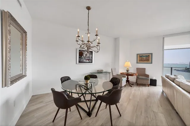 a dining room with furniture a chandelier and wooden floor