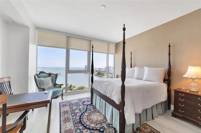 a bedroom with a bed and large windows