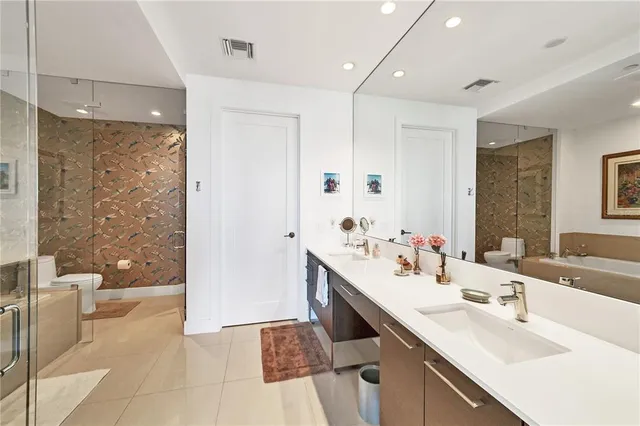 a bathroom with a double vanity sink a mirror and a shower