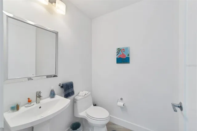a bathroom with a sink mirror and toilet