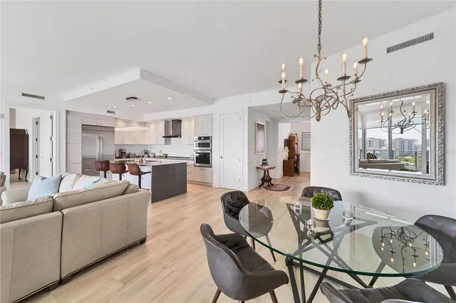 a living room with furniture kitchen and a chandelier