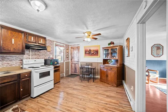 a kitchen with stainless steel appliances granite countertop a stove cabinets and wooden floor