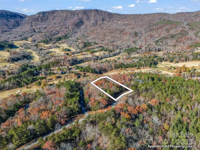 an aerial view of house with yard and mountain view in back