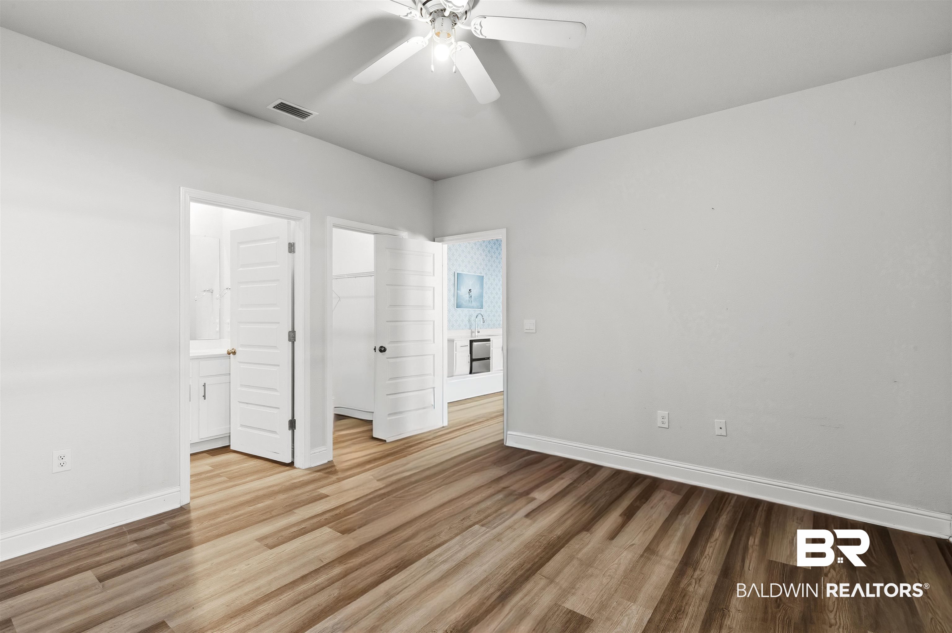 485 Shepard Street Gulf Shores, AL 36542 - Photo 28 of 53 In-Law suite bedroom featuring a walk in closet, light wood finished floors, a ceiling fan, and ensuite bath