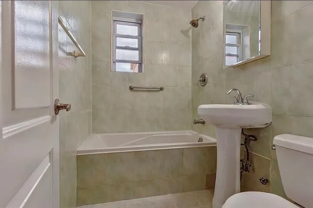 a bathroom with a sink mirror toilet and bathtub