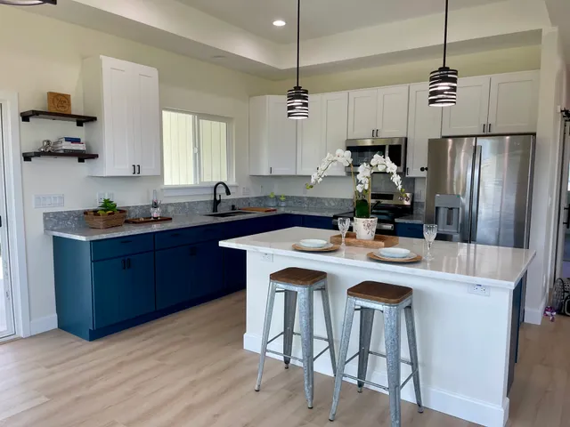 a kitchen with a sink a refrigerator a stove a dining table and chairs