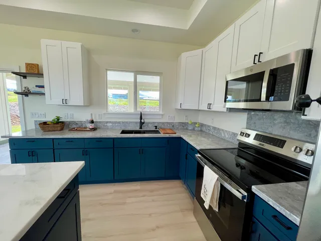 a kitchen with stainless steel appliances granite countertop a stove a sink and a microwave