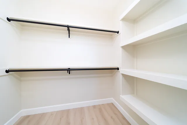 a view of a closet with wooden floor