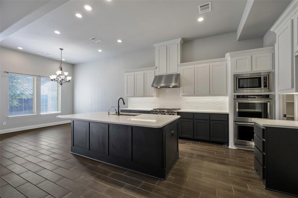 941 Leola Lane Allen, TX 75013 - Photo 14 of 37 a kitchen with kitchen island granite countertop a sink cabinets and stainless steel appliances