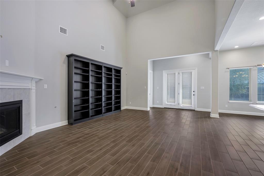 941 Leola Lane Allen, TX 75013 - Photo 18 of 37 an empty room with wooden floor fireplace and windows