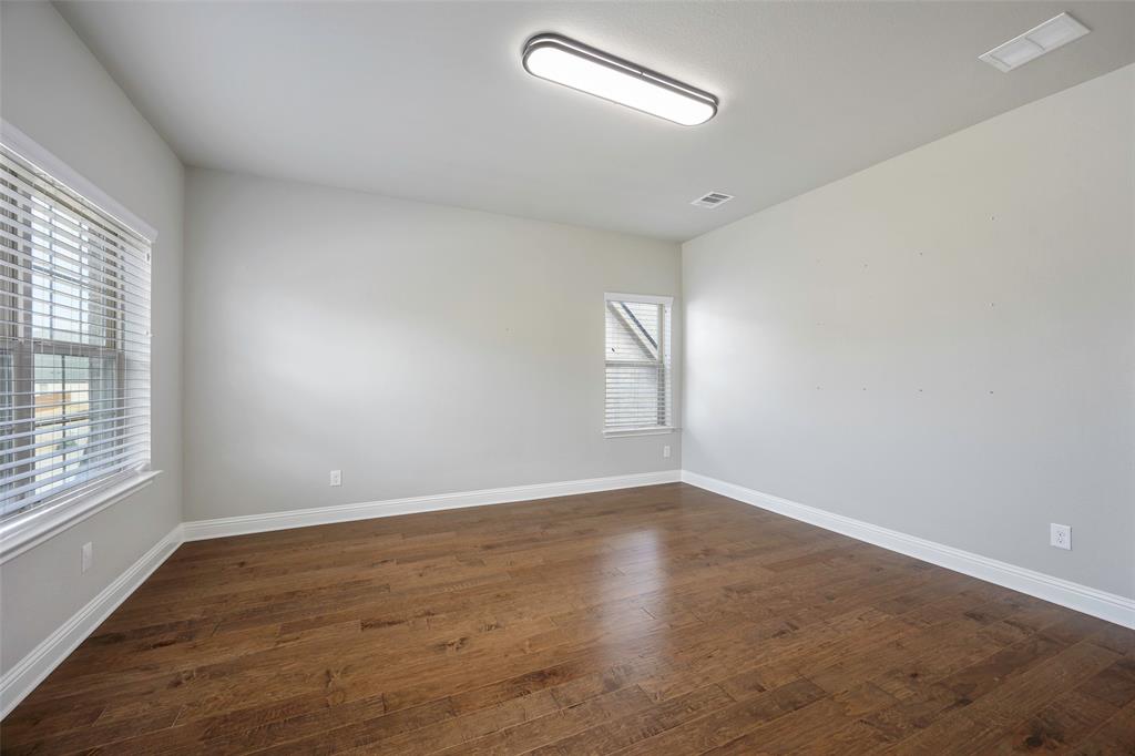 941 Leola Lane Allen, TX 75013 - Photo 26 of 37 an empty room with wooden floor and windows