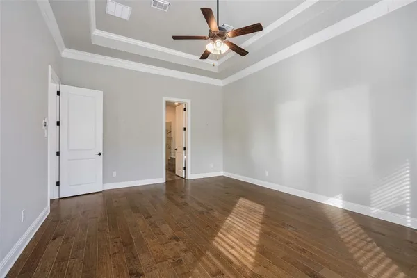a bedroom with a large bed and a flat tv screen on dresser
