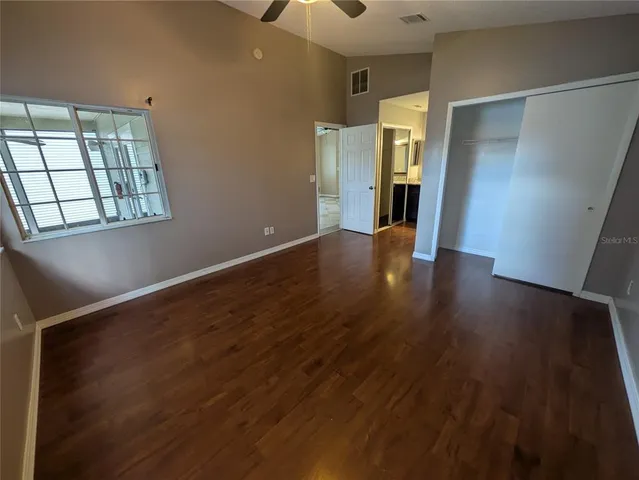 an empty room with wooden floor and windows
