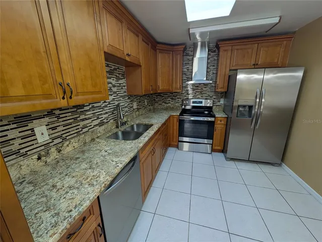 a kitchen with stainless steel appliances granite countertop a sink stove and refrigerator
