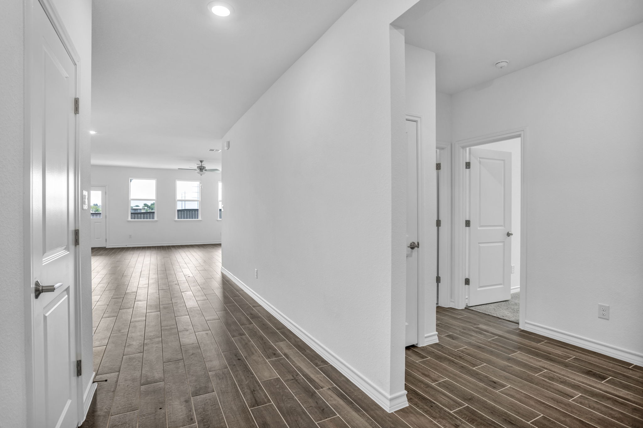 131 Adeline Road Hutto, TX 78634 - Photo 10 of 30 Long plank tile flooring creates a seamless flow throughout this bright hallway and living area.