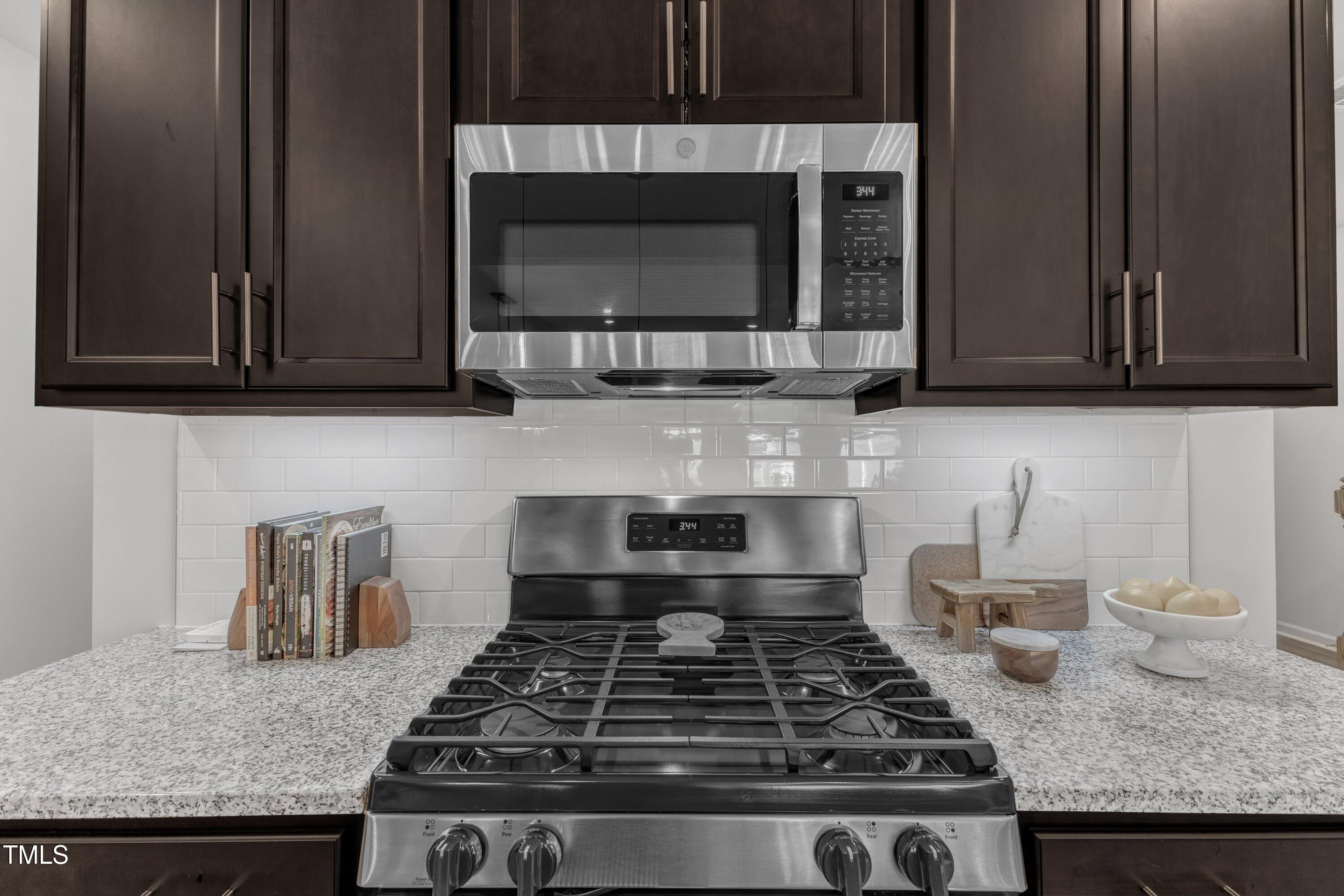 5814 Empathy Lane Raleigh, NC 27616 - Photo 15 of 48 a kitchen with granite countertop a stove and a microwave