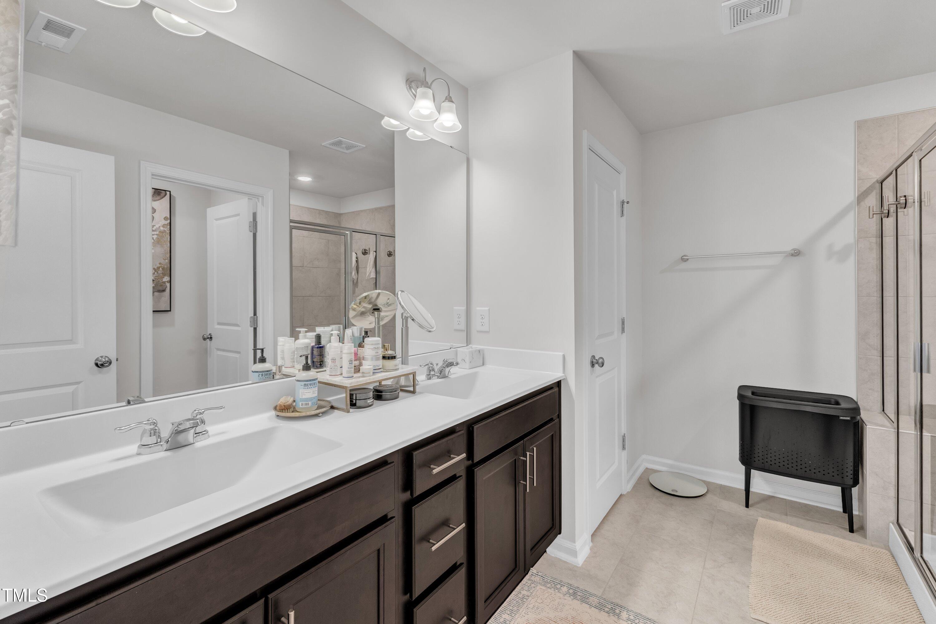 5814 Empathy Lane Raleigh, NC 27616 - Photo 27 of 48 a bathroom with a double vanity sink a mirror and a bathtub