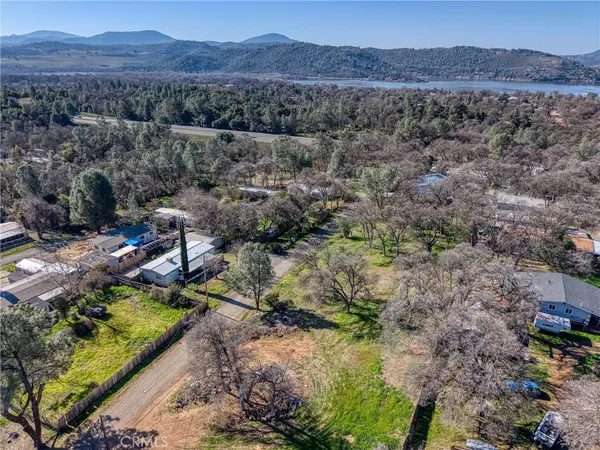 an aerial view of house with yard and mountain view in back
