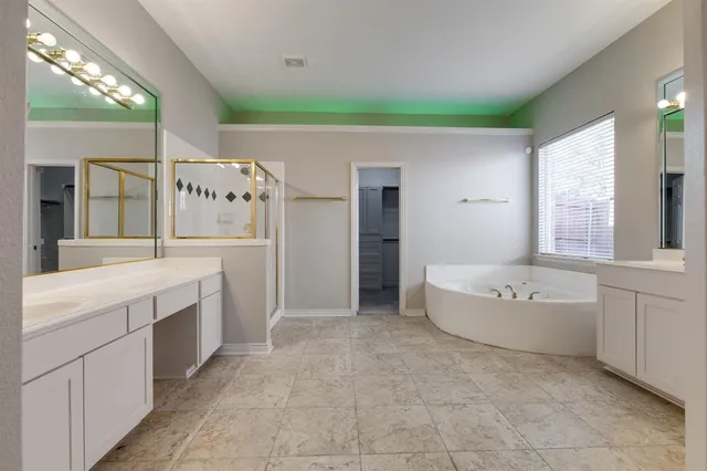 a spacious bathroom with a tub sink and mirror