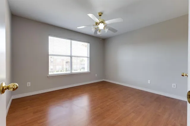 an empty room with windows and fan