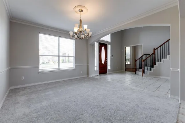 a view of an empty room with chandelier and a window