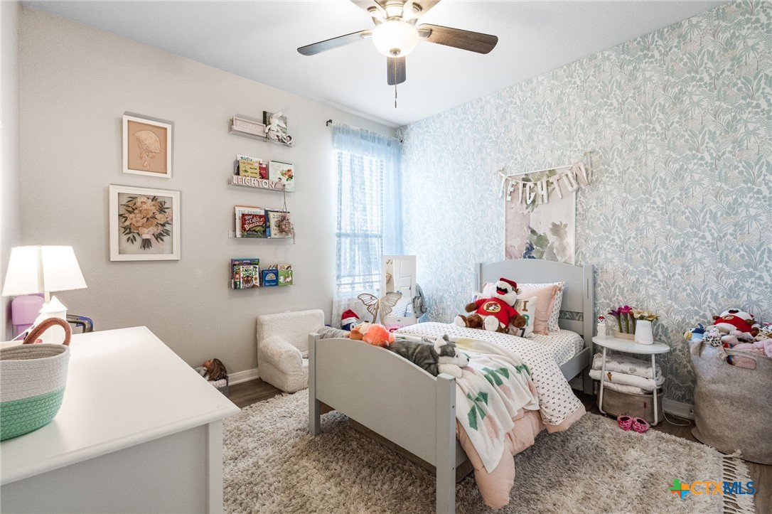 7320 Hammermill Lane Temple, TX 76502 - Photo 24 of 32 a bedroom with a bed and a chandelier
