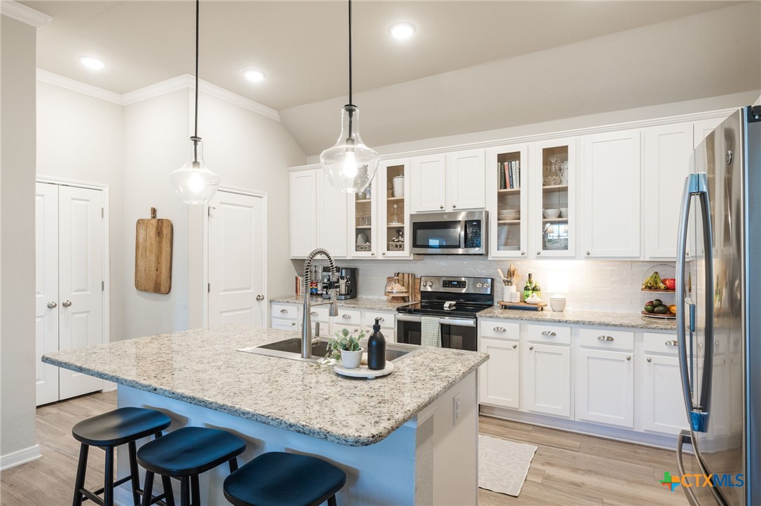 7320 Hammermill Lane Temple, TX 76502 - Photo 9 of 32 a kitchen with stainless steel appliances granite countertop a sink a stove a refrigerator a dining table and chairs