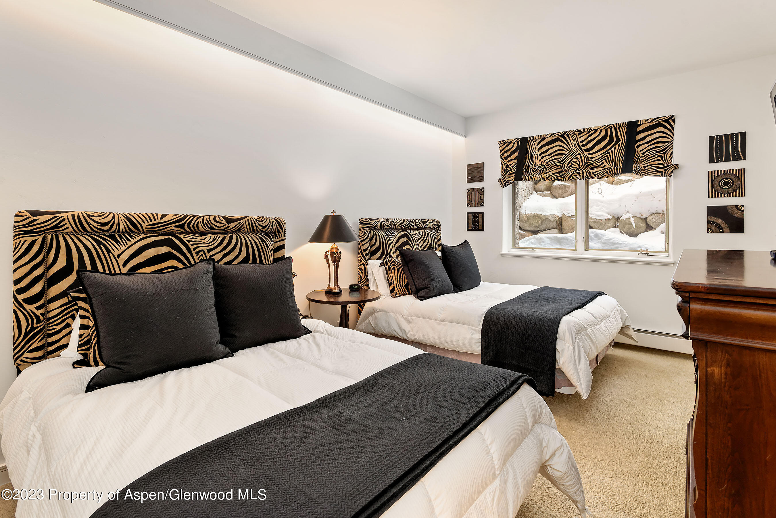 926 East Durant Avenue, Unit 3 Aspen, CO 81611 - Photo 12 of 20 a bedroom with two beds and a large mirror next to a window