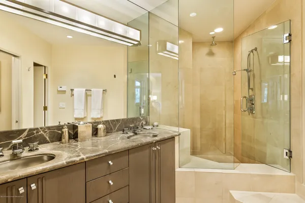 a bathroom with a granite countertop sink mirror and shower