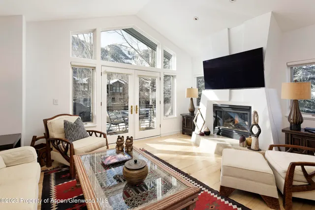 a living room with furniture a flat screen tv and a fireplace