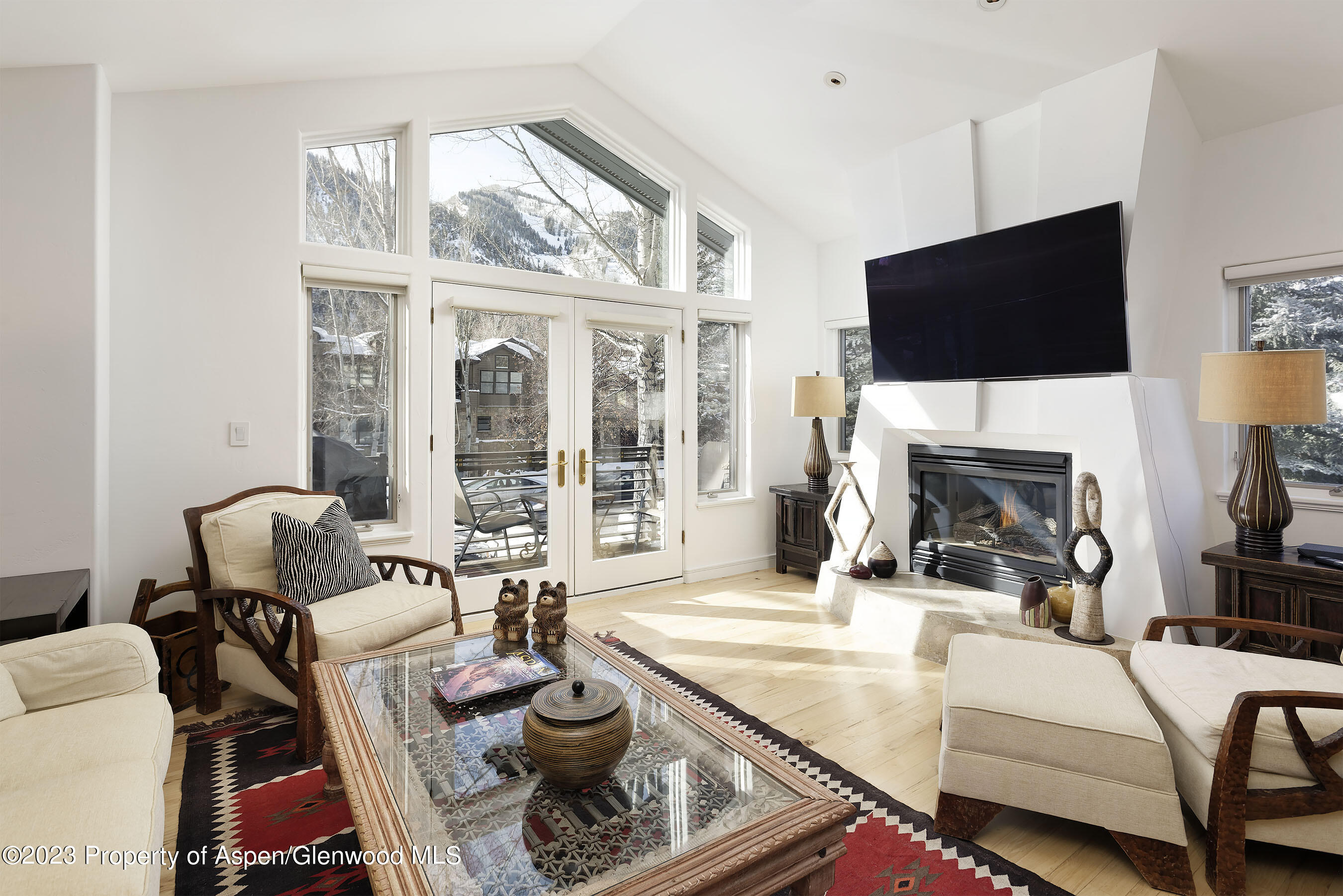 926 East Durant Avenue, Unit 3 Aspen, CO 81611 - Photo 3 of 20 a living room with furniture a flat screen tv and a fireplace