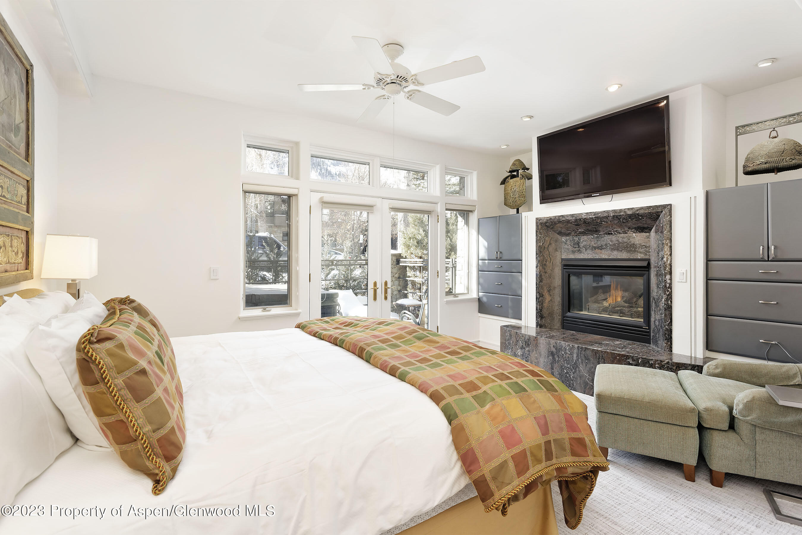 926 East Durant Avenue, Unit 3 Aspen, CO 81611 - Photo 7 of 20 a spacious bedroom with a bed a fireplace and a flat screen tv