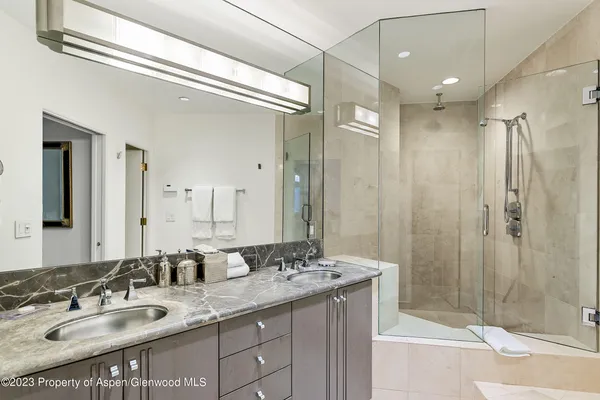 a bathroom with a granite countertop sink shower and a mirror