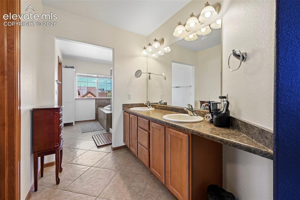 10643 Pictured Rocks Drive Peyton, CO 80831 - Photo 26 of 37 a spacious bathroom with a granite countertop sink a mirror and a vanity