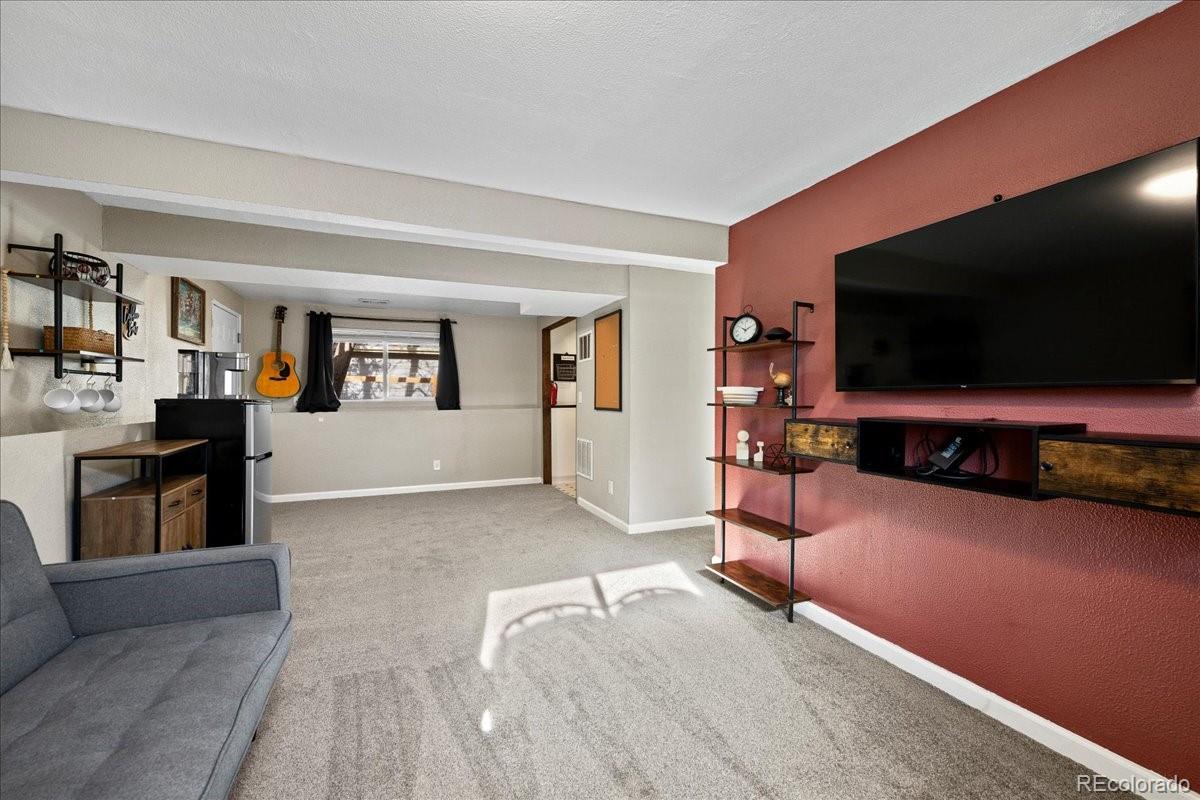 205 Walnut Street Frederick, CO 80530 - Photo 20 of 31 a living room with furniture and a flat screen tv
