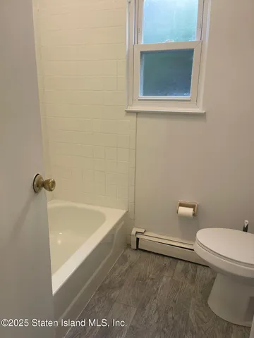 a bathroom with a toilet and a bath tub