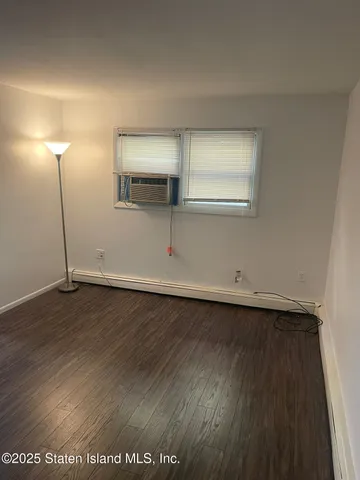 an empty room with wooden floor and mirror