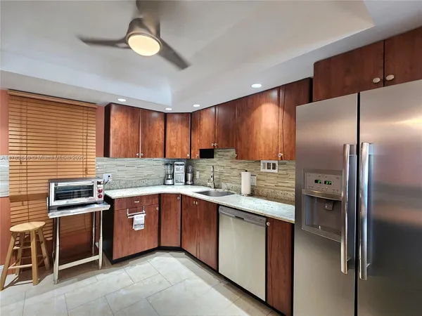 a kitchen with stainless steel appliances granite countertop a sink a stove and refrigerator