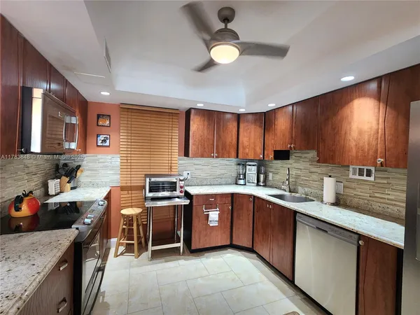 a kitchen with stainless steel appliances granite countertop sink stove top oven and cabinets
