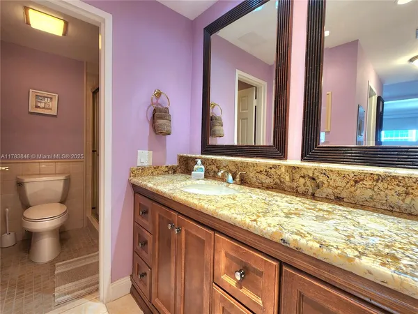 a bathroom with a granite countertop sink and a mirror