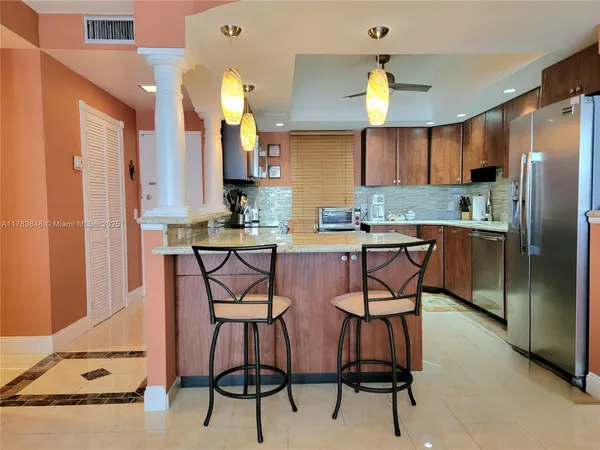 a kitchen with stainless steel appliances a table chairs and a refrigerator