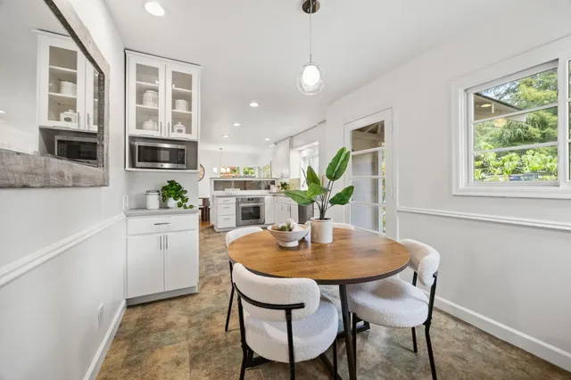 a kitchen with a dining table chairs and refrigerator