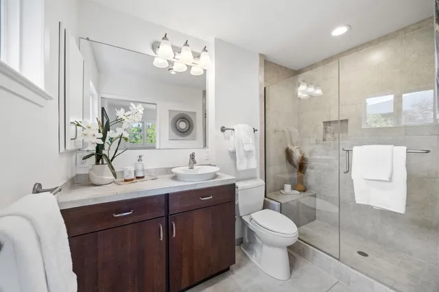 a bathroom with a granite countertop toilet sink and mirror