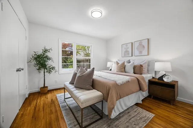 a bedroom with a bed and a potted plant