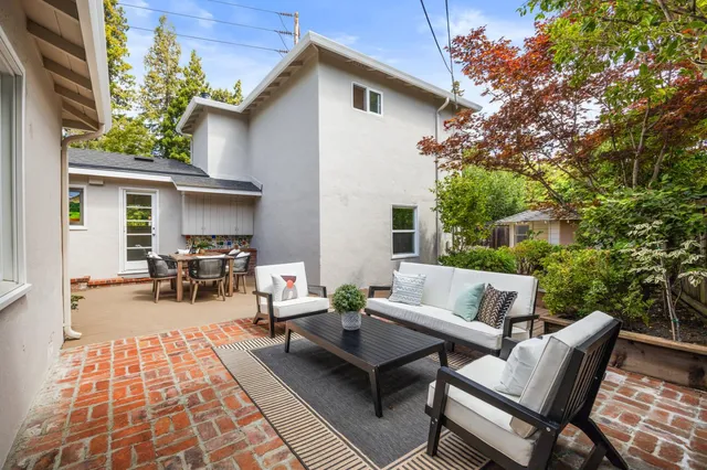 a view of a patio with dining table and chairs with wooden floor and fence