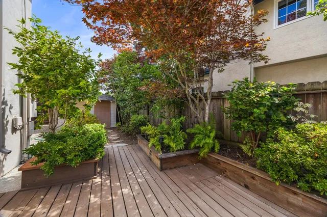 a view of balcony with wooden floor and potted plants