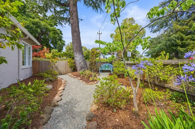 a backyard of a house with a lot of flower plants