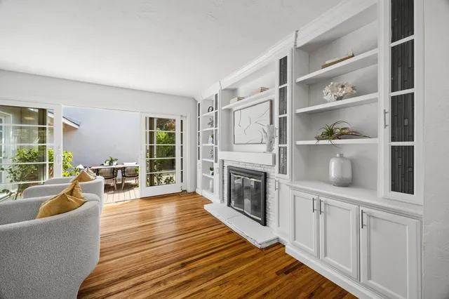 a living room with furniture a fireplace and a large window