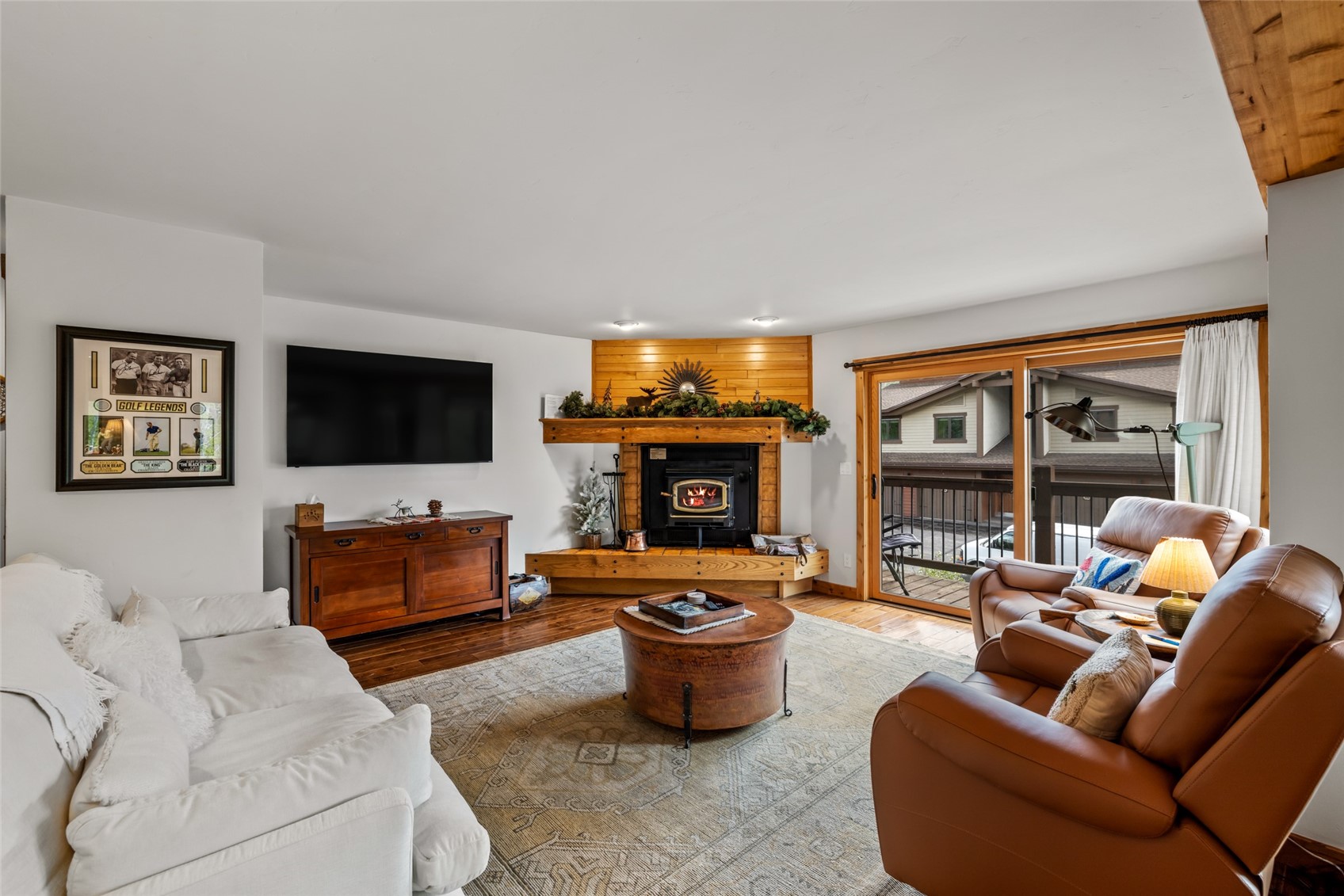 1655 Ranch Road, Unit 403 Steamboat Springs, CO 80487 - Photo 6 of 36 Living area with a warm lit fireplace and wood finished floors